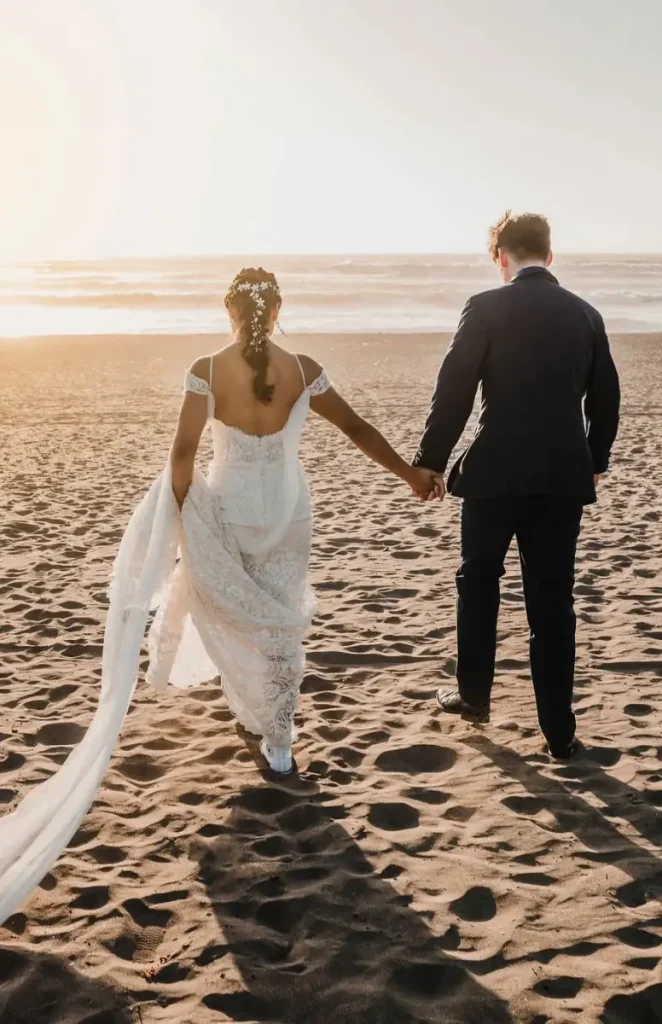 Novios caminando por la playa el día de su boda