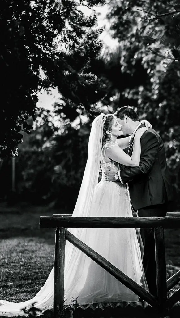 Foto de novios recién casados sobre un puente